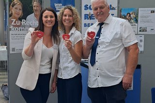 3 Personen am Infostand