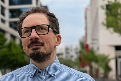 Dr. Bernhard Goodwin Dr. Bernhard Goodwin vor modernen Häusern.