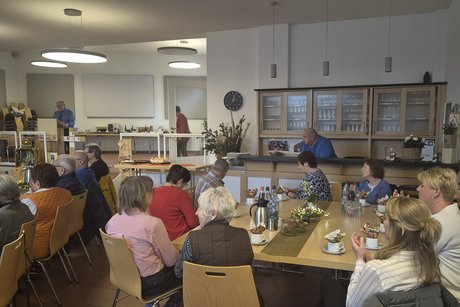 Der Vorsitzende steht am Redepult und spricht zu den G&auml;sten im Saal.