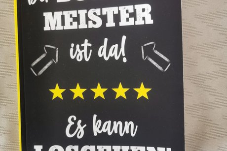 Bild zeigt ein Notizbuch mit der Aufschrift: "Der B&Uuml;RGERMEISTER ist da! - Es kann LOSGEHEN!"
