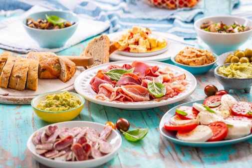 Picknicktisch, der mit verschiedenen Vorspeisen und Dips gedeckt ist. 