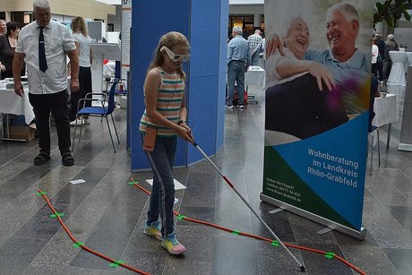 Sehbehindertenparcours eine Erfahrung für Groß und Klein Mödchen mit Blindenstock