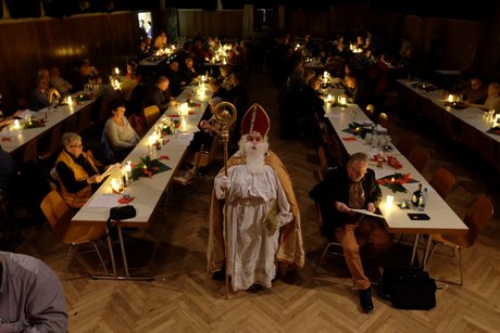 Alle Schutzengel der Hoffnung leuchten im abgedunkelten Saal, in der Mitte steht der Nikolaus