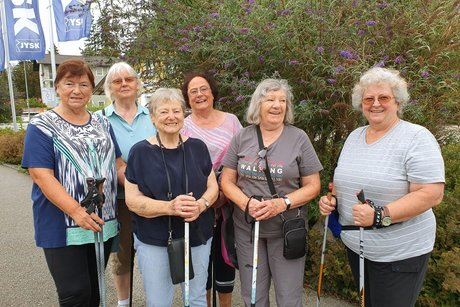 6 Damen mit Nordicwalkingausrüstung am Trefgpunkt