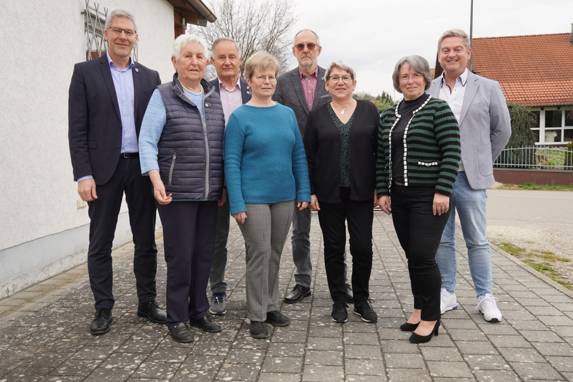 Der neu gewählte Vorstand mit Gästen steht vor dem Gebäude der Schützengesellschaft Hubertus.