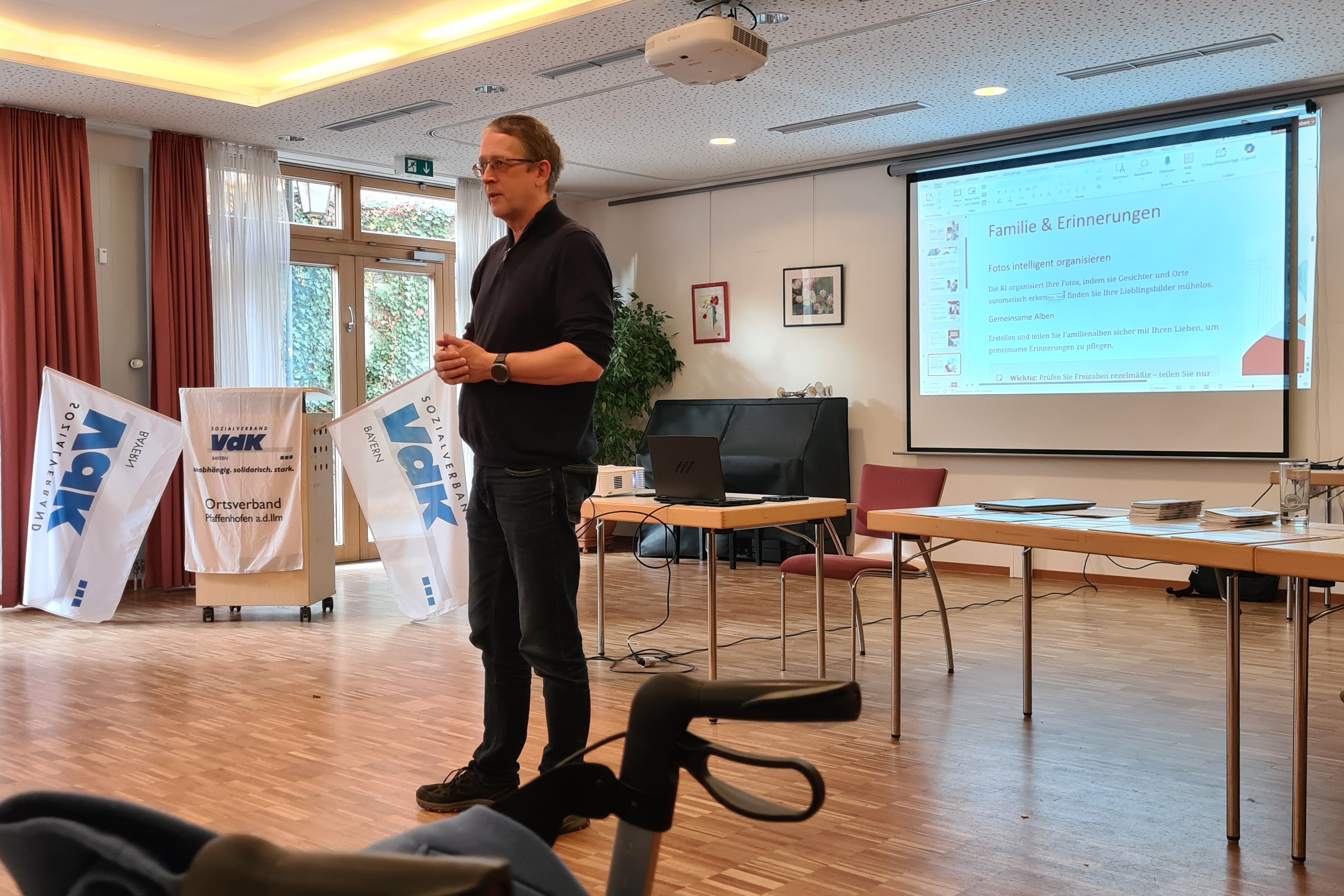 Referent Herr Arvid Rosinski Herr Rosinski vor einem Beamer mit Leinwand, Pult mit VdK-Fahnen und VdK Pultdecke, Tisch mit Infomaterial