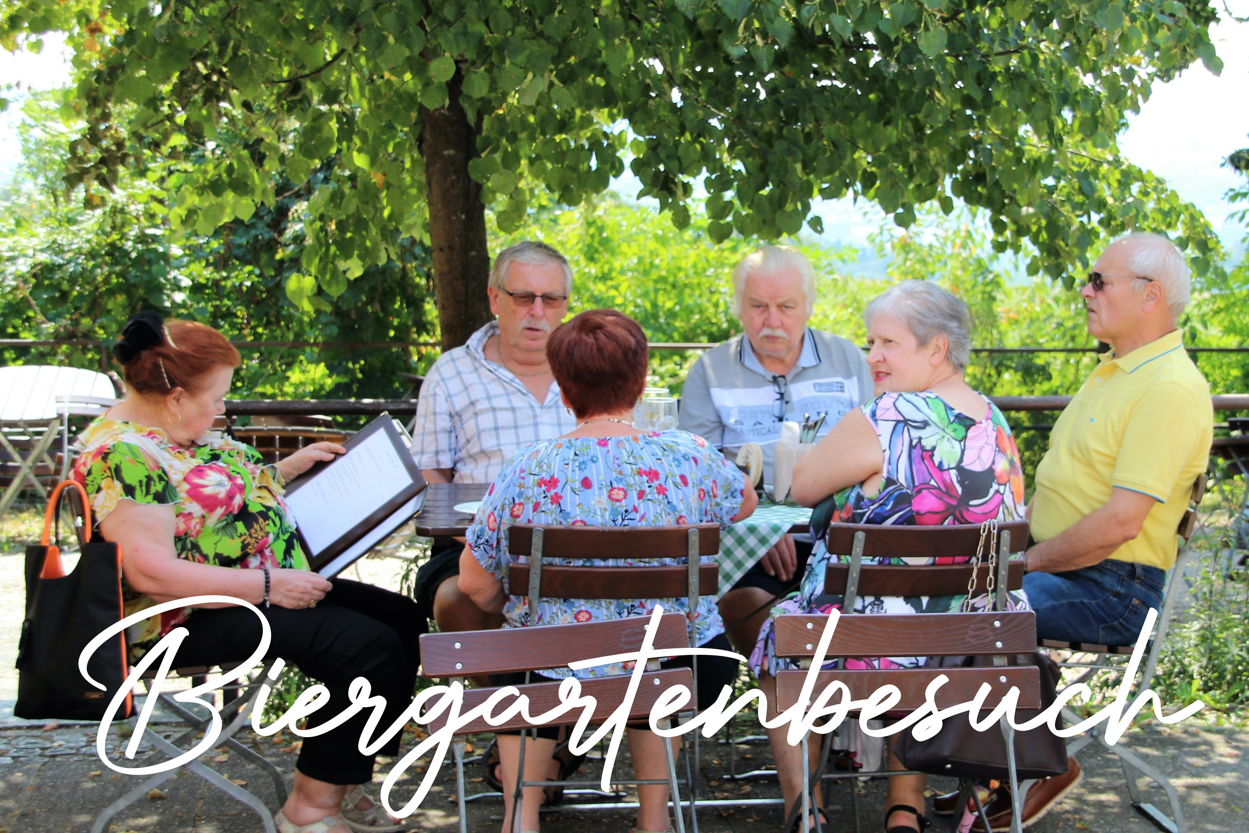 6 VdK-Mitglieder sitzen am Biertisch im Biergarten und unterhalten sich.