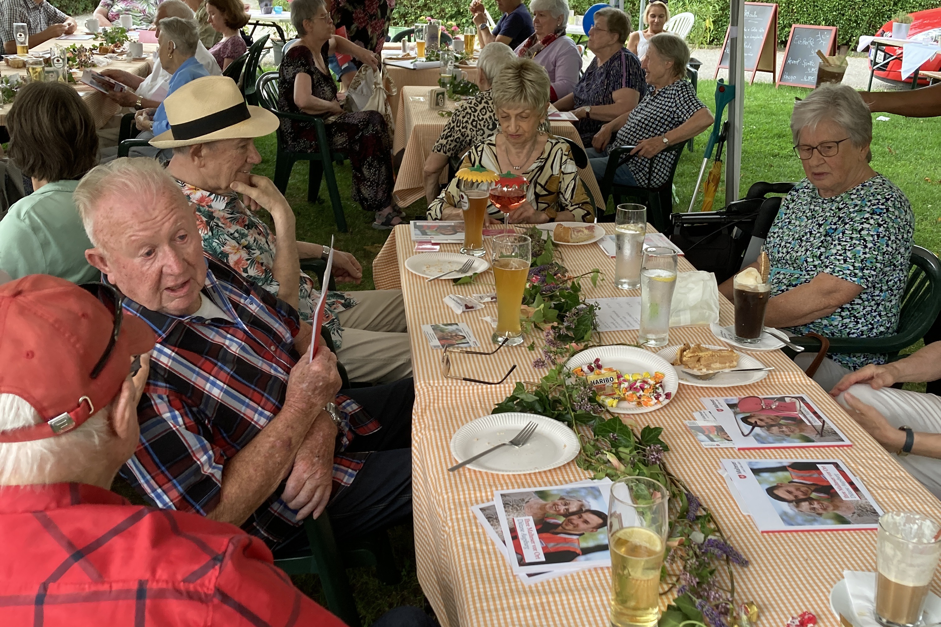 Mehrere Personen unter dem Zeltdach beim Gespr&auml;ch