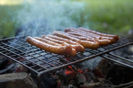 5 Paar Bratw&uuml;rste liegen auf einem Grill und sind bald fertig