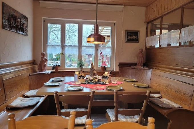 Gastraum des "Haarther Keller" mit Blickrichtung zum Eingangsbereich zu sehen sind ein gro&szlig;er Tisch mit einer rundum Sitzbank. der Tisch ist einladend rustikal eingedeckt