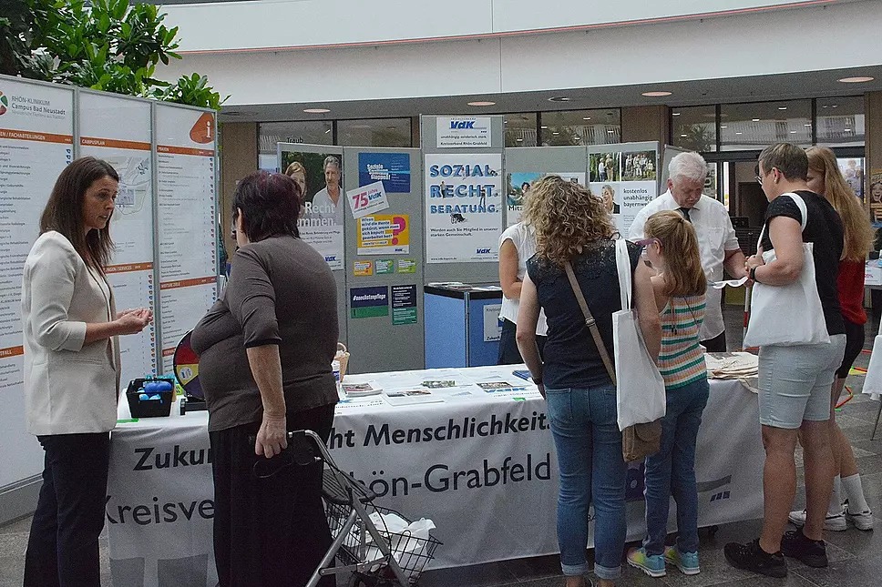 Das Bild zeigt den Info-Stand mit Besuchern