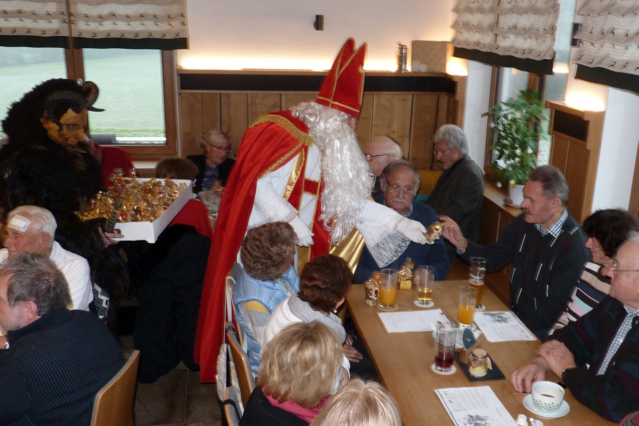 Nikolaus mit Krampus verteilt Geschenke an Besucher