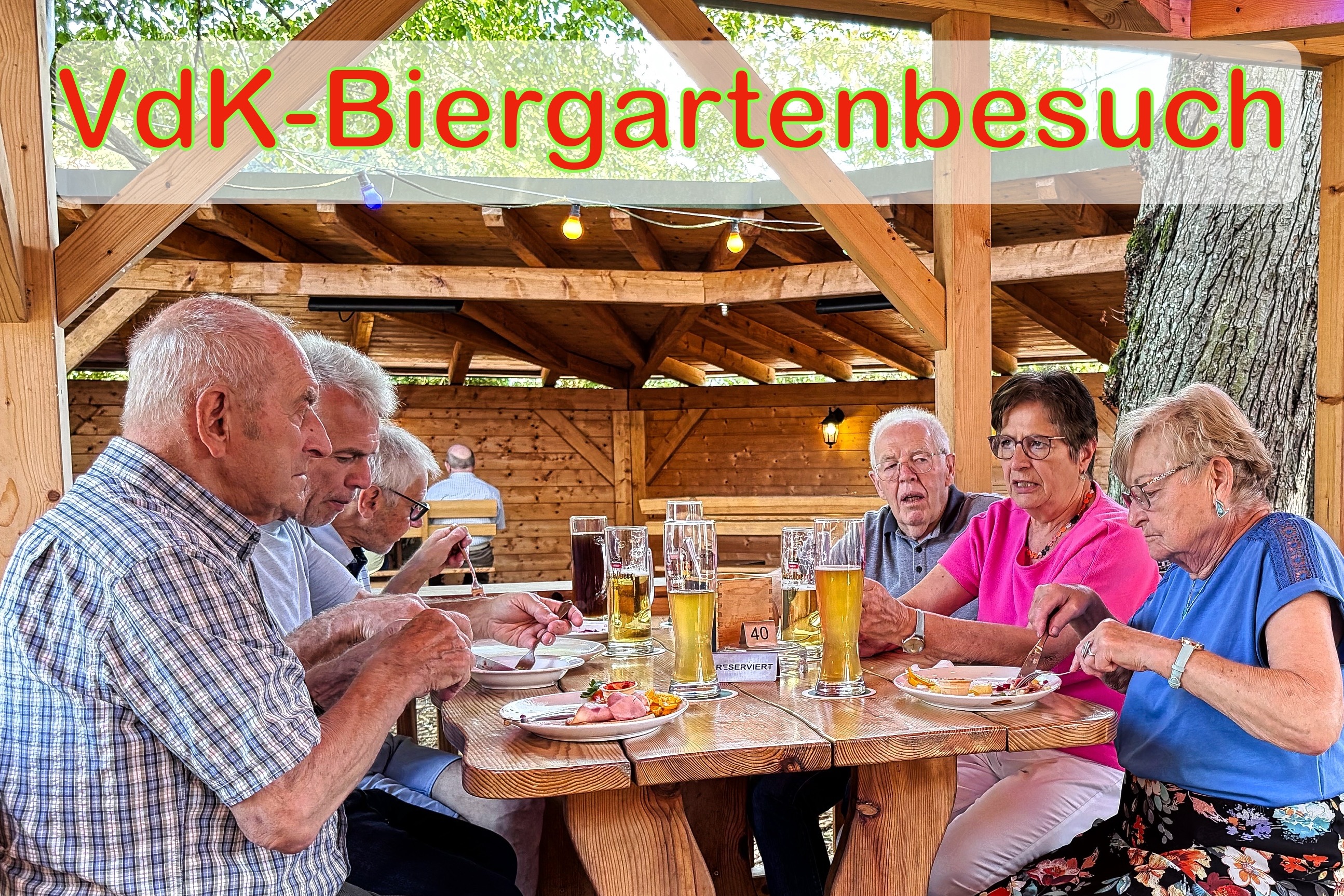 Menschen sitzen in gem&uuml;tlicher Runde im Biergarten