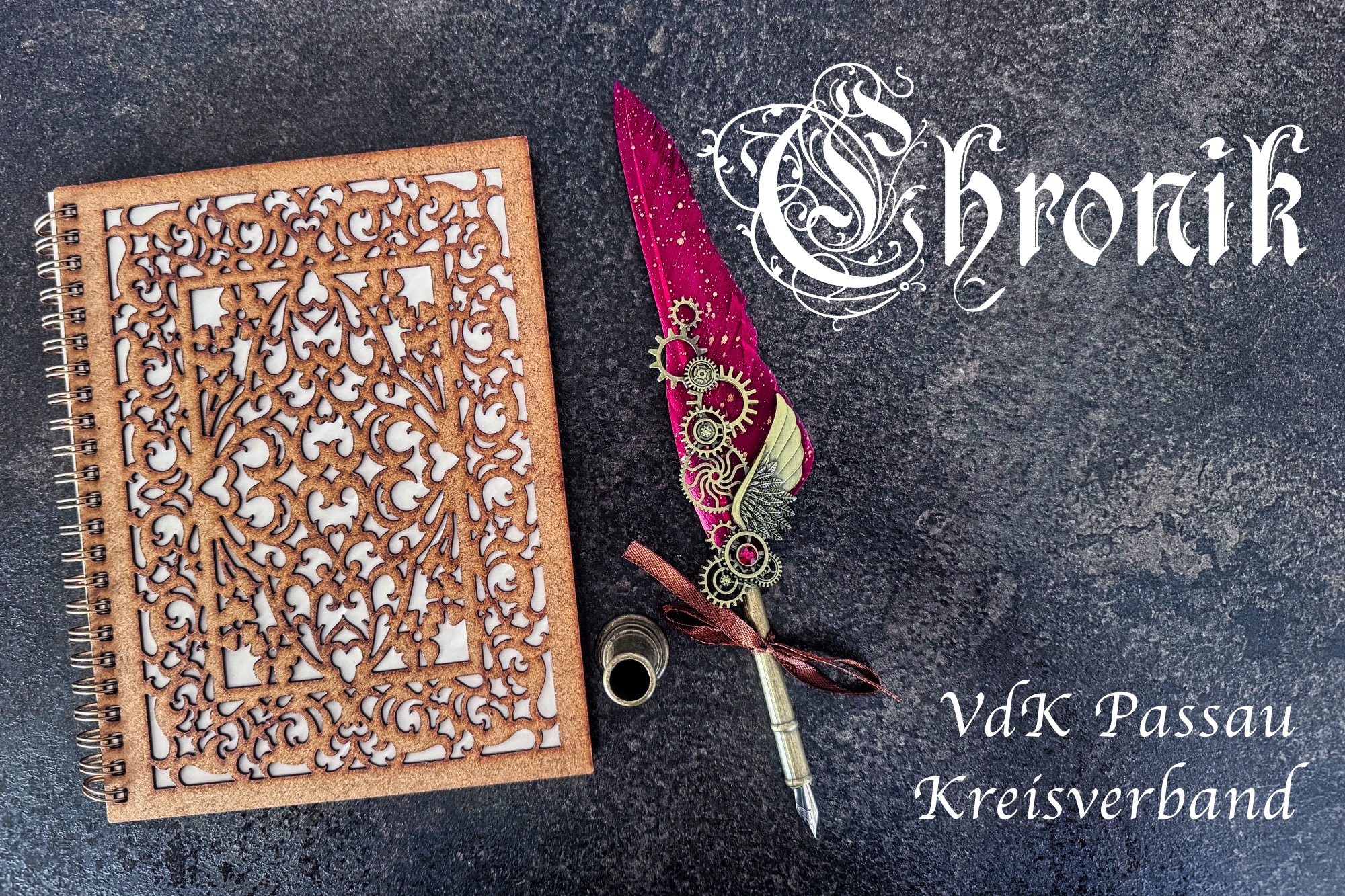 Zu sehen ist ein Buch mit verziertem Einband und einer kostbaren Kalligraphie Schreibfeder