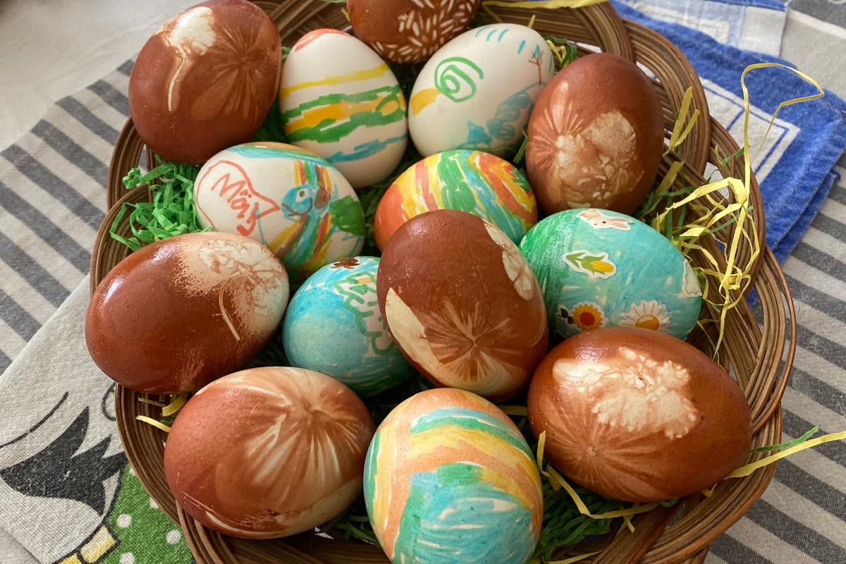 Ostereier auf dem Bild sieht man gefärbte Eier im Körbchen auf dem Tischtuch