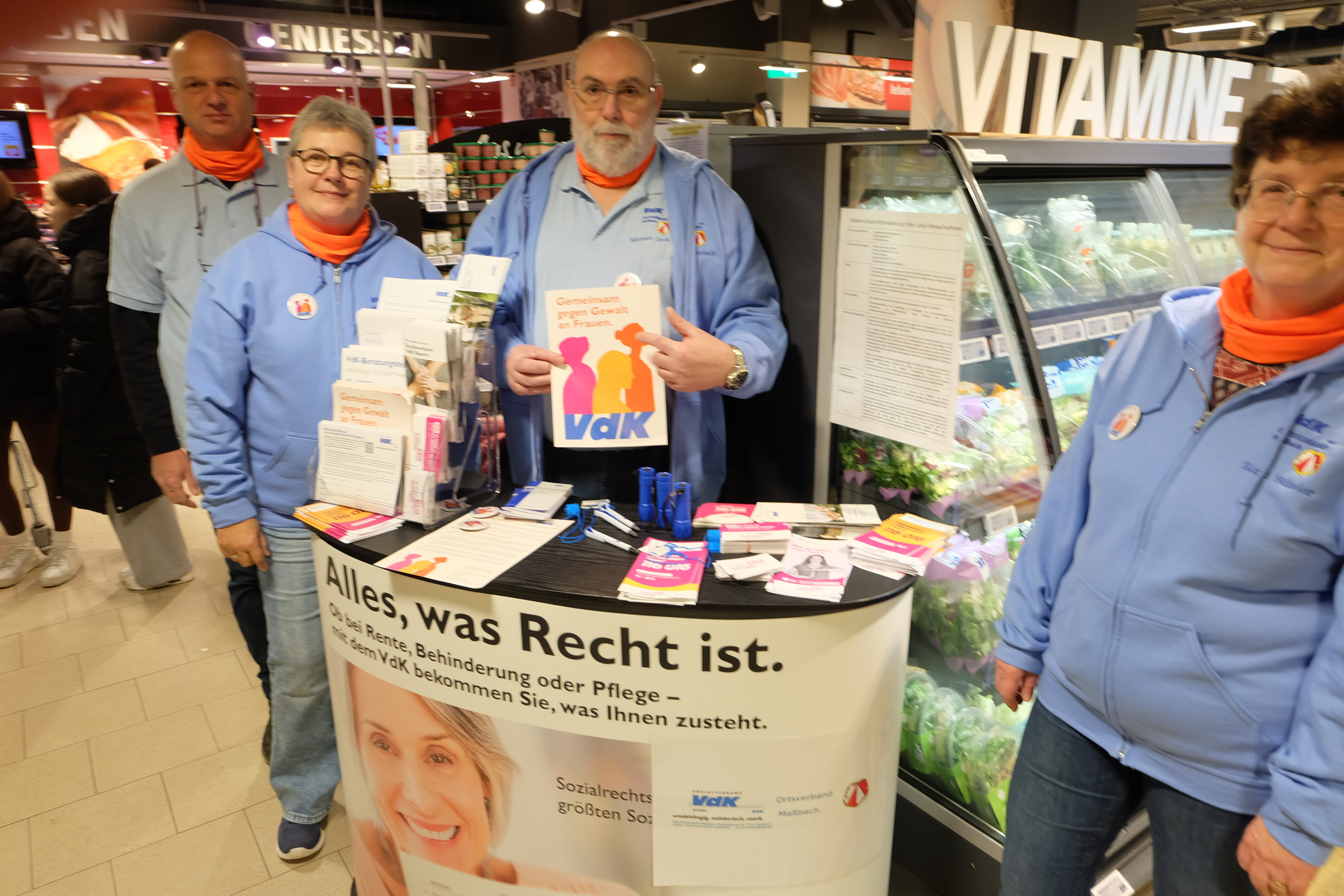 4 Vorstandsmitglieder des VdK OV Ma&szlig;bach stehen am Infotisch im Rewe Markt Ma&szlig;bach