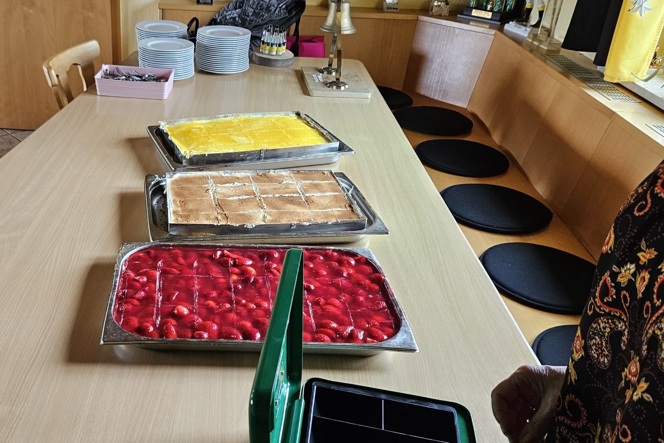 3 Bleche mit Kuchen stehen auf einem Tisch, Erdbeerkuchen, Tiramisukuchen, Pfirsichkuchen