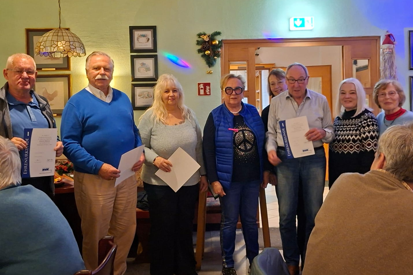 Vier Damen und drei Herren teilweise mit Urkunden