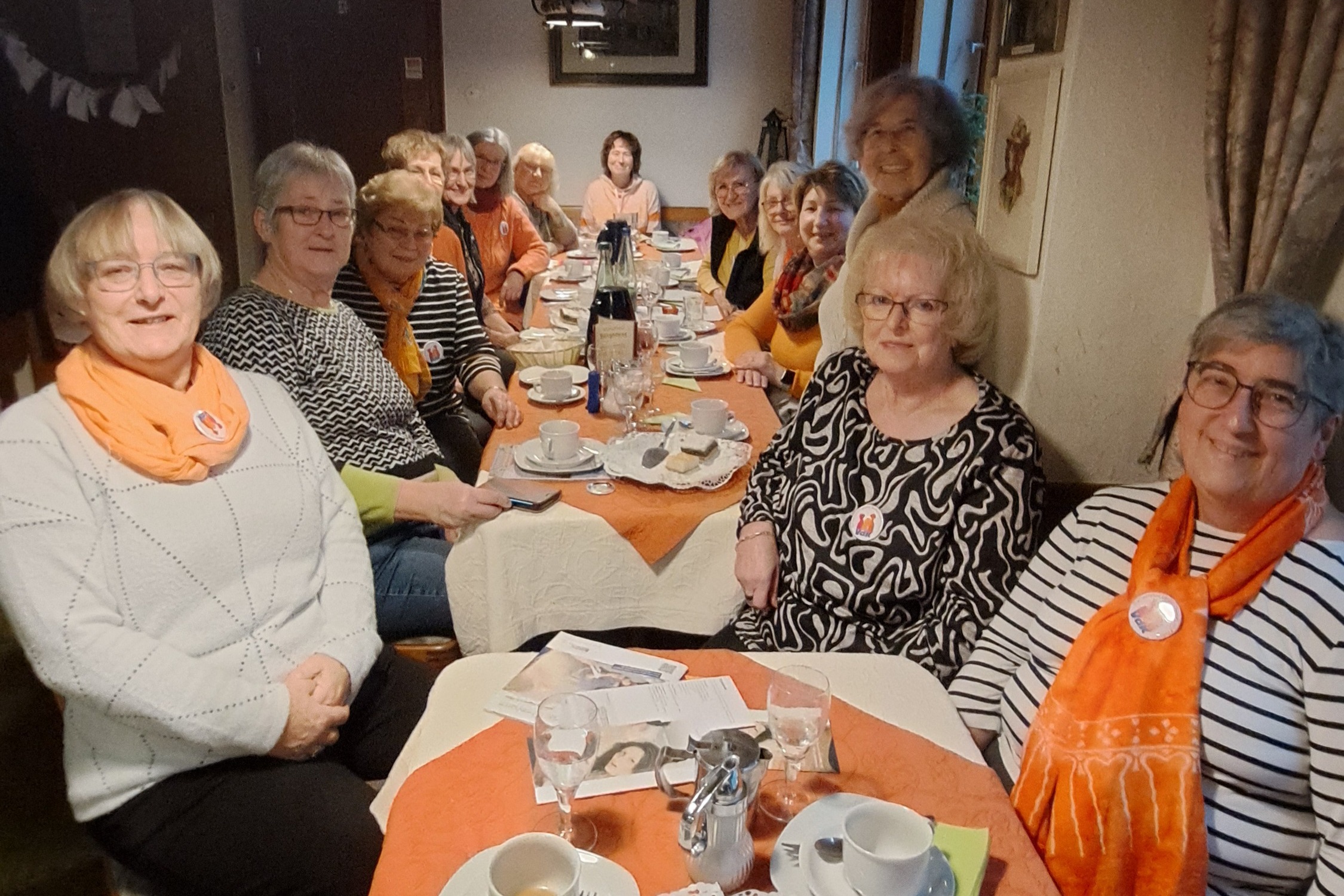Informationsveranstaltung anlässlich "Orange Day" am 25.11.20225 Frauen sitzen zusammen am Tisch - alle tragen aus Solidarität ein orangefarbenes Kleidungsstück