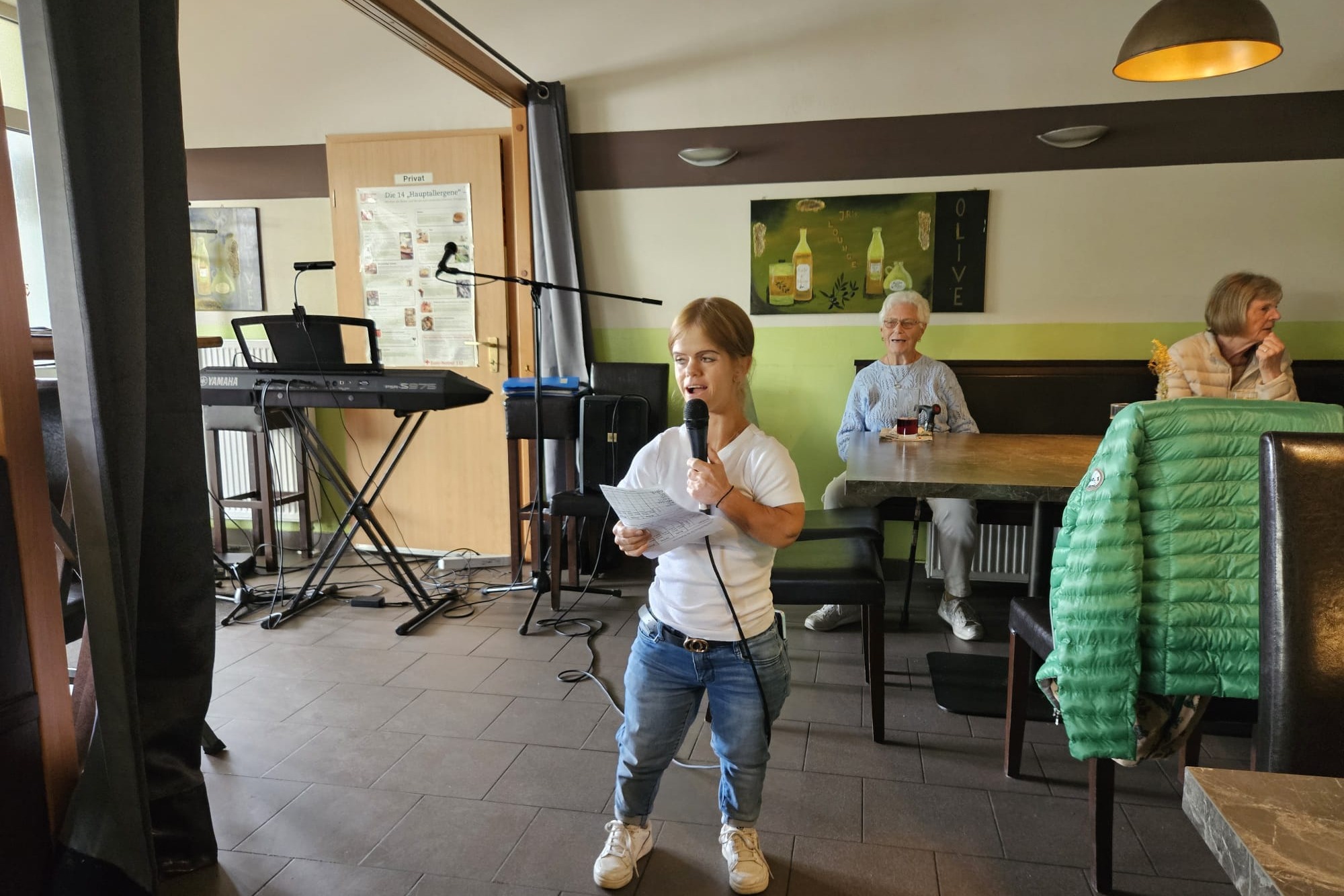 Begrüßung Die Vorsitzende hält das Mikro und begrüßt die Gäste