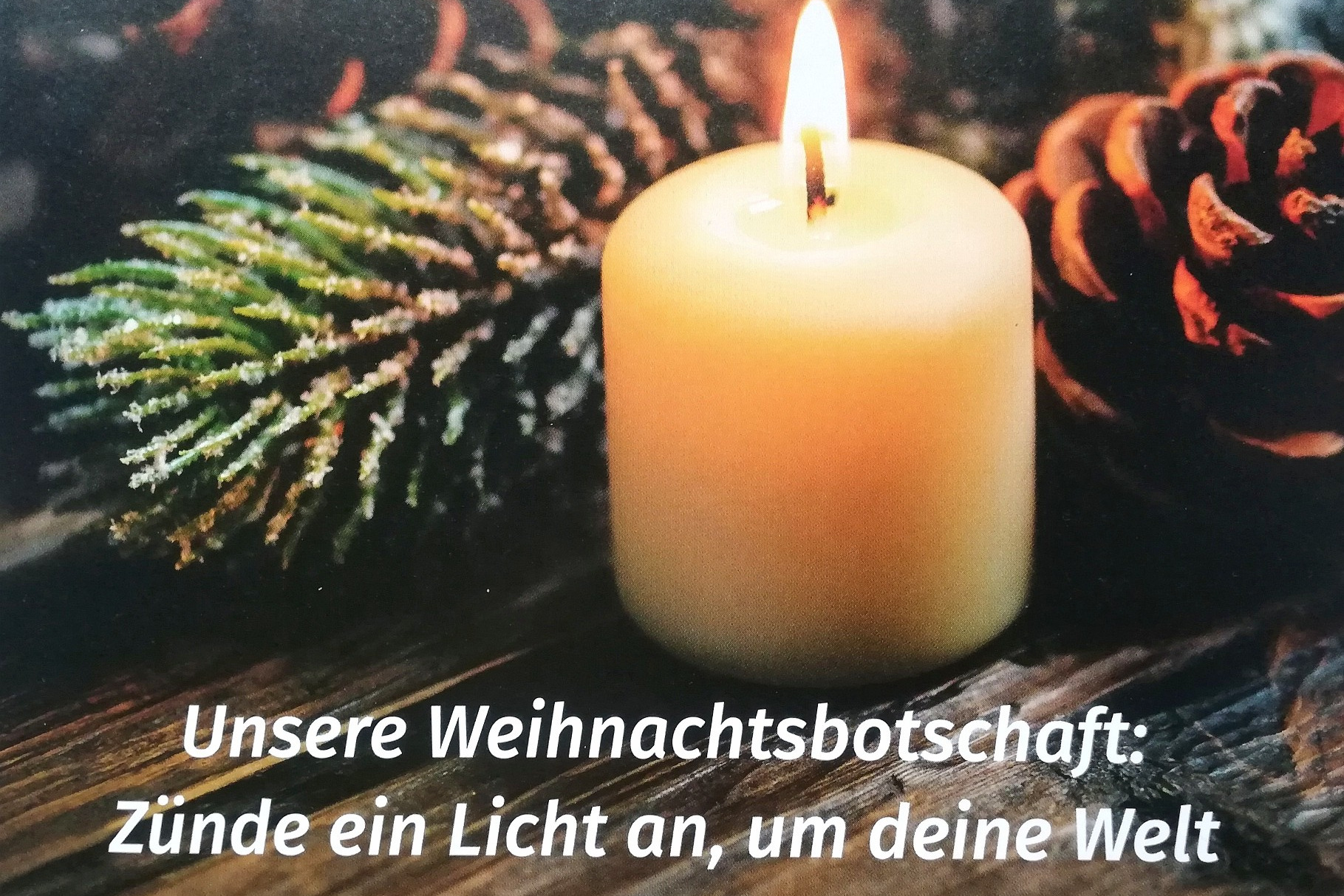 1 gelbe brennende Kerze vor Tannenzweig und Tannenzapfen - ein warme ruhige Atmosph&auml;re