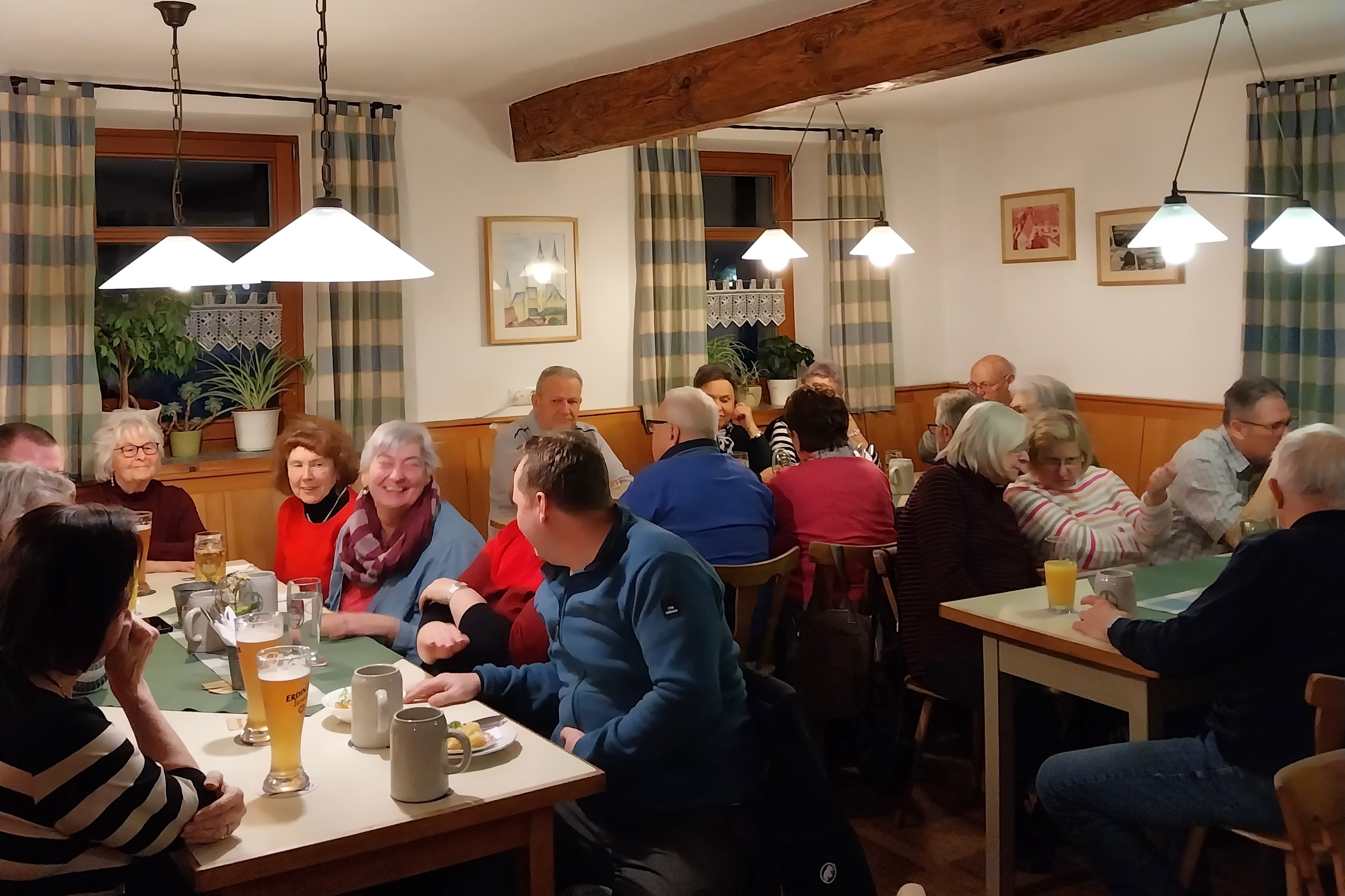 Mitglieder und G&auml;ste sitzen in der Gaststube beim Heringessen und unterhalten sich.