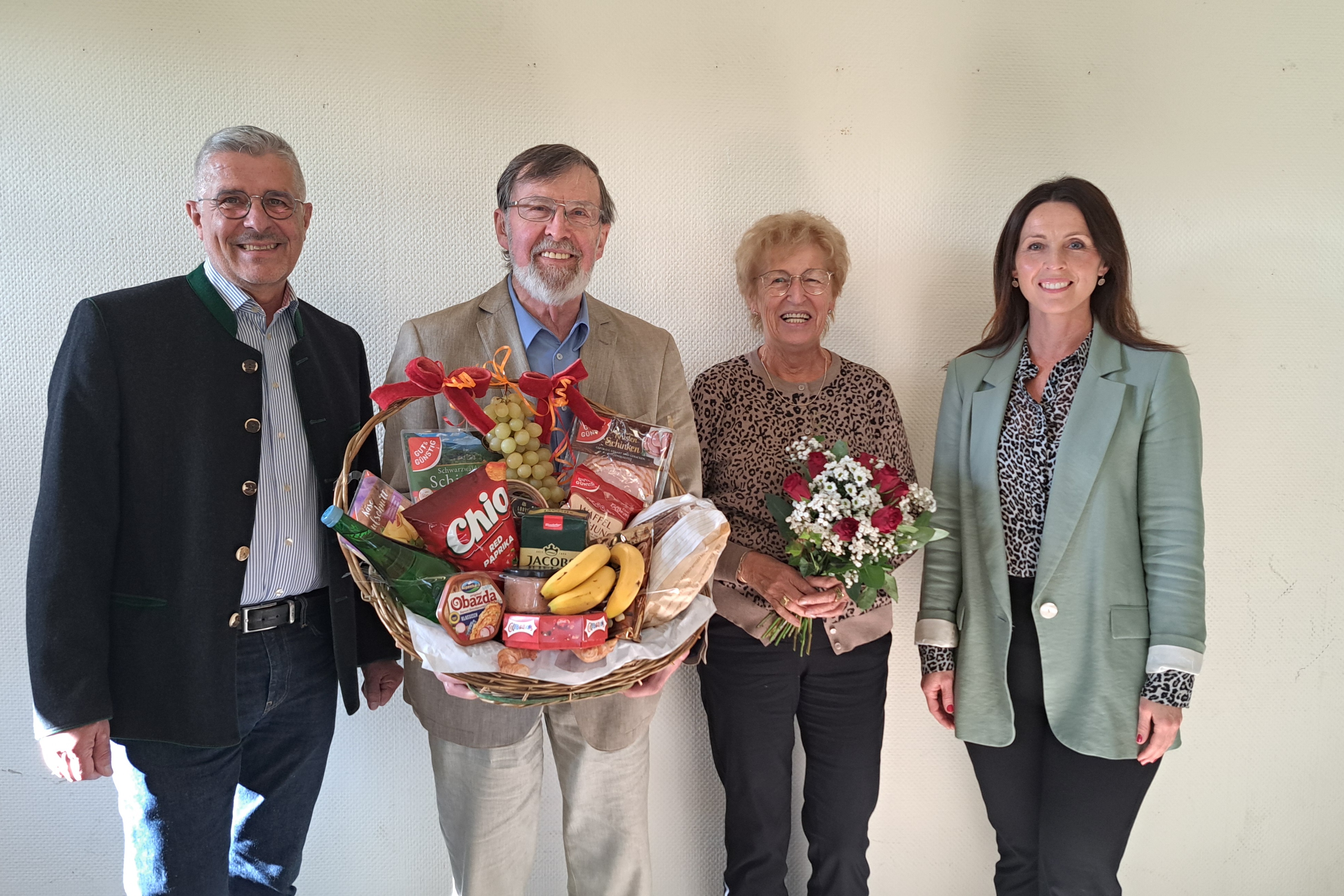 vier Personen in der Mitte die Ausscheidenden mit Blumen und Geschenkkorb